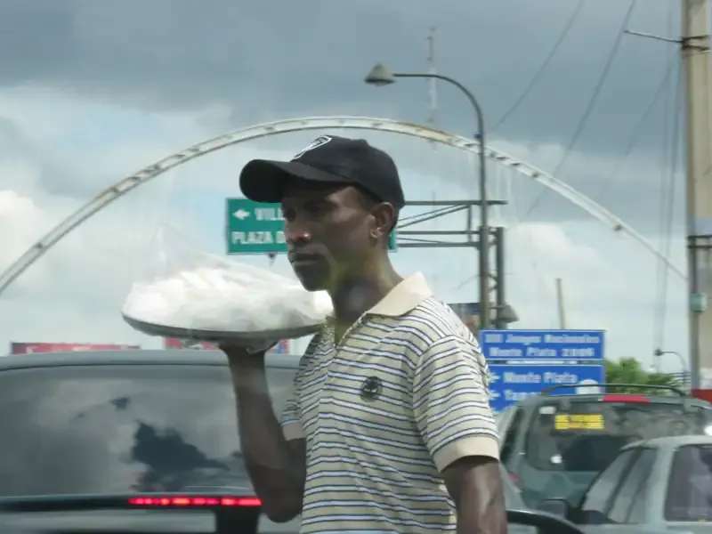 單手托著一大盤食物在車陣中叫賣的小販